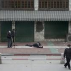Dos manifestantes observan el cuerpo de un activista tiroteado mientras otro se aleja del escenario