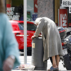 Un mendigo revisa una papelera en una de las calles del centro de la ciudad. BRUNO MORENO