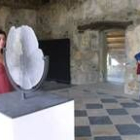 Algunos visitantes contemplando una escultura de un hombre