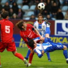 El jugador de la Deportiva, Jonathan Valle, intenta rematar acrobáticamente un balón rodeado de dos