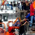 Los miembros el equipo de rescate desembarca el cadáver del patrón del pesquero