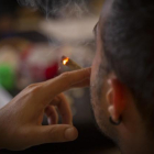 Un fumador consume cannabis en el interior de un club