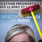 Un empleado del Frente Nacional pega un cartel electoral de Marine Le Pen al inicio de la campaña.