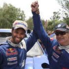 Sainz (d), ganador del Dakar 2010, levanta el brazo junto al qatarí Nasser, segundo.