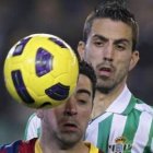 El defensa bético, Isidoro Gómez, lucha por el balón con el centrocampista del Barça, Xavi.