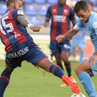 El jugador del Girona, Felipe Sanchón, trata de marcharse del defensa del Huesca, Carlos Akapo.