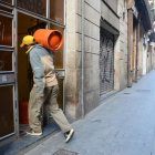 Un hombre entra con una bombona de butano en una vivienda en el Raval.