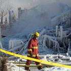 Un bombero camina entre los restos de la residencia incendiada en L'Isle-Verte (Canadá), este jueves.