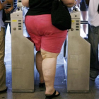 Una mujer obesa entra en el metro de Nueva York.