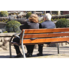 Dos personas mayores descansan en un banco en uno de los parques de la capital.
