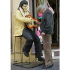 Un mayor se entretiene con la guitarra de «Elvis» en el centro de León