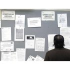 Un desempleado consultas ofertas de trabajo en una Oficina de los Servicios Públicos de Empleo.