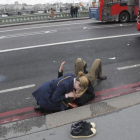 Una mujer atiende a un herido en el puente de Londres.