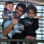 Luis Suárez, acompañado de sus hijos, saluda a los aficionados uruguayos apostados ante su casa cerca de Montevideo.