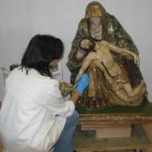 La restauradora Pilar Castillo, de Proceso Arte 8, trabaja en la talla