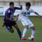 David Álvarez se lleva el balón a pesar del agarrón de un jugador bañezano