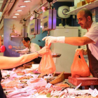 Una mujer compra pescado fresco en un mercado de Barcelona.