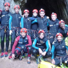 Los integrantes de los ‘Lions Factory’ posan delante de las Cuevas de Valporquero junto al monitor que guió su recorrido.
