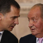 Juan Carlos dialoga con su hijo, ayer durante la firma de su abdicación.