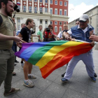 Manifestantes homófobos tratan de romper una bandera gay de un grupo de homosexuales en Moscú
