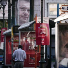 Un hombre pasa junto a un cartel electoral de Meïmarakis (derecha) y otro de Tsipras (arriba), este miércoles en Atenas.