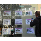Un hombre consulta los anuncios de una inmobiliaria de Barcelona.