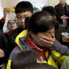 Una familiar de uno de los pasajeros del vuelo de Malaysia Airlines se tapa la boca, rodeada de periodistas, este sábado en el hotel de Pekín.