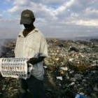 Un seguidor de René Préval observa las papeletas de votos encontradas en vertederos de basura