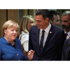 Merkel habla con Pedro Sánchez en Bruselas, en presencia del presidente de Francia Emmanuel Macron (de espaldas). OLIVIER HOSLET
