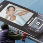 Un trabajador coloca un anuncio de un teléfono móvil en una valla publicitaria