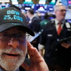 Un operador de Wall Street luce una gorra conmemorativa de los 25.000 puntos alcanzados por el Dow Jones.