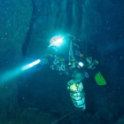 Uno de los espeleólogos avanza por el primer sifón de la cueva