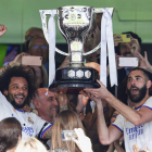 Mancelo y Benzema levantan el trofeo de campeón de Liga tras recibirlo del presidente de la Federación Española, Luis Rubiales, en el palco del Bernabéu. PABLO GARCÍA