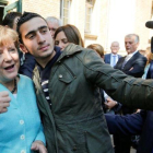 El refugiado sirio Anas M. se hace un selfie con Merkel, en septiembre del 2015.
