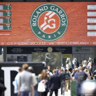 El público pasea por los alrededores de la pista Suzanne Lenglen mientras se disputan partidos de la roda previa de Roland Garros, este jueves.