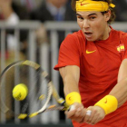 El tenista español Rafael Nadal devuelve una bola ante el argentino Juan Mónaco, en el primer partido de la final de la Copa Davis.