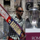 Un seguidor del Barça se hace una foto junto a la copa en el Coliseo