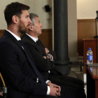 Messi y su padre, ayer, en el banquillo de los acusados durante el juicio por fraude. ALBERTO ESTEVEZ
