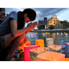 Una joven reza antes de tirar al agua velas en recuerdo de las víctimas de Hiroshima.