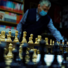 Un empleado coloca las figuras en el tablero en la tienda especializada la casa del ajedrez en Madrid. EMILIO NARANJO