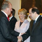 El rey Juan Carlos recibe el saludo del presidente de Castilla y León al inicio de la conferencia de