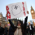 Un manifestante alza una pancarta contra Trump a las puertas del Parlamento británico.