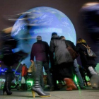 Peatones pasan junto a un globo de la Tierra gigante en la víspera de la inauguración.