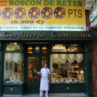 Sergio González, a la puerta de la confitería con un roscón y el enorme cartel con el premio.