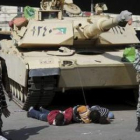 Soldados egipcios retienen a tres supuestos saqueadores en una calle en El Cairo.