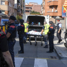 Miembros de la funeraria judicial retiran el cadáver del agresor de la comisaría de los Mossos en Cornellà. /