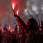 Amigos y camaradas del activista asesinado Roman Ratushnyi encienden bengalas durante su funeral en Kiev. ROMAN PILIPEY