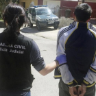Una guardia civil conduce a un detenido en Puerto Lumbreras (Murcia).