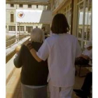 Una enfermera acompaña a una mujer afectada por el alzhéimer