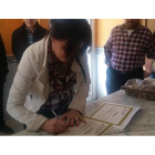 La madre de la niña, Sara Álvarez, firmando el diploma.